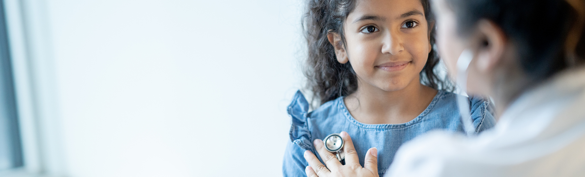 doctor listening to young girls heart